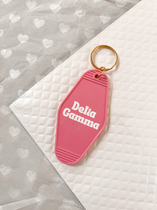Delta Gamma Motel Hotel Key Chain in Hot pink with white letters and gold ring. DG