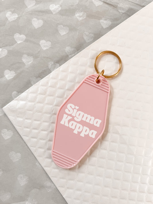 Sigma Kappa Motel Hotel Key Chain in Soft pink with white letters and gold ring. SK