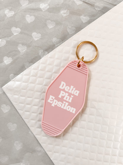 Delta Phi Epsilon Motel Hotel Key Chain in Soft pink with white letters and gold ring. DPhiE