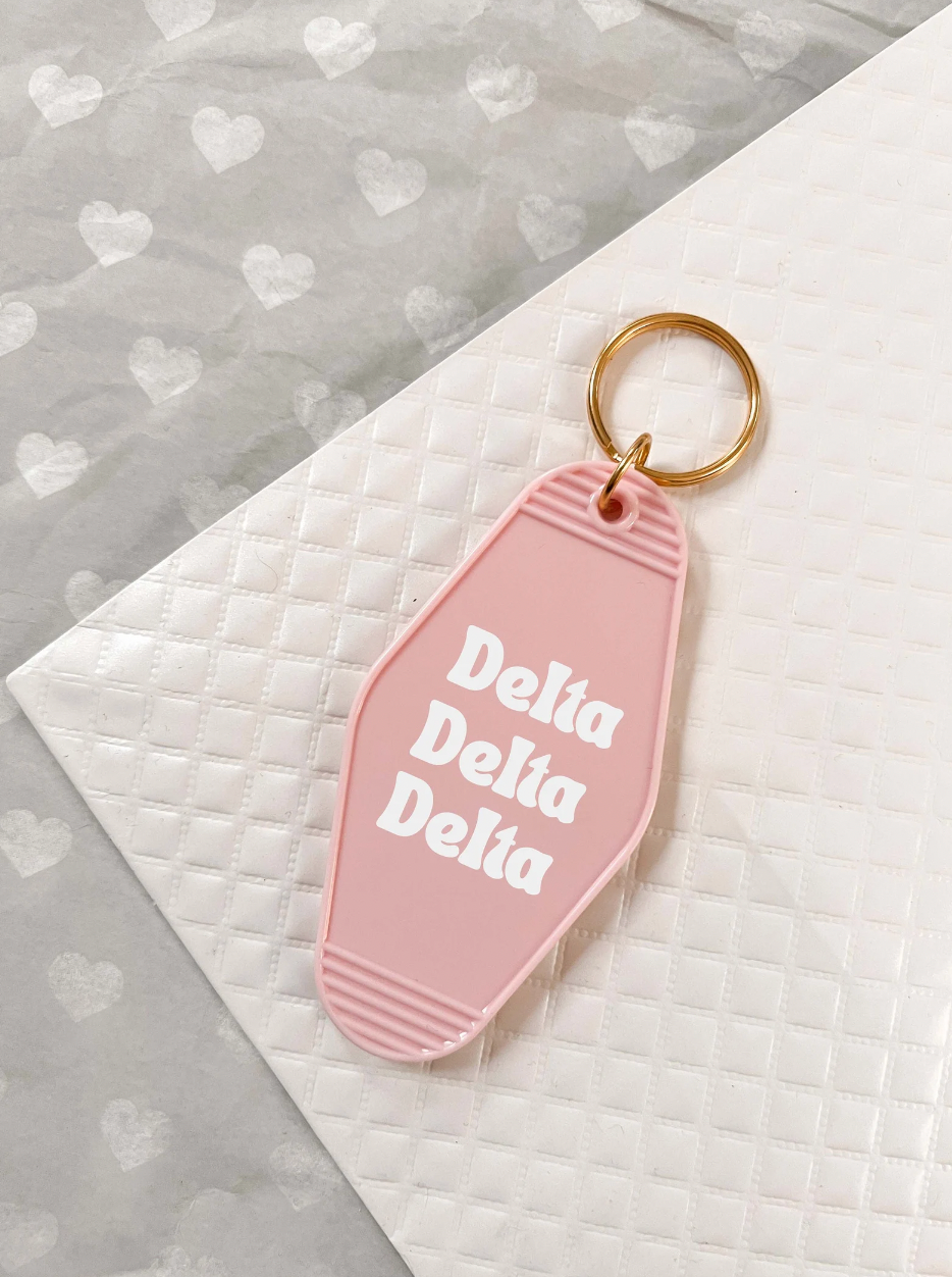 Delta Delta Delta Motel Hotel Key Chain in Soft pink with white letters and gold ring. TriDelta